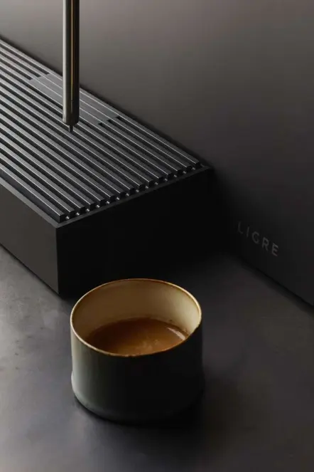 Close-up reference of a matte-black object and dark cup with warm interior.