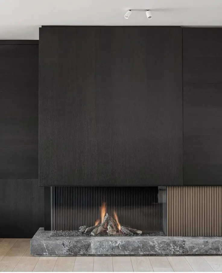 Reference interior with a minimal linear fireplace set into black wall panels.