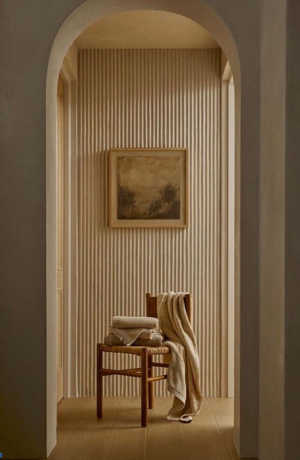 Warm neutral interior viewed through a rounded arch, used as an atmosphere reference.