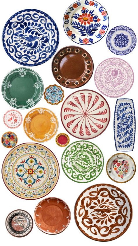 Assortment of colourful decorative ceramic plates on a pale ground.