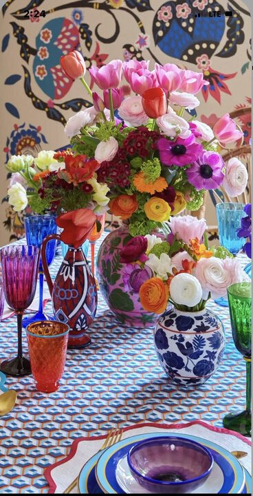 Colourful floral tablescape with patterned ceramics and saturated textiles, used as a concept reference.